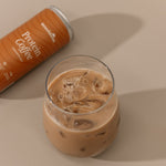 Glass of iced coffee with a can of Protein Coffee on a beige background
